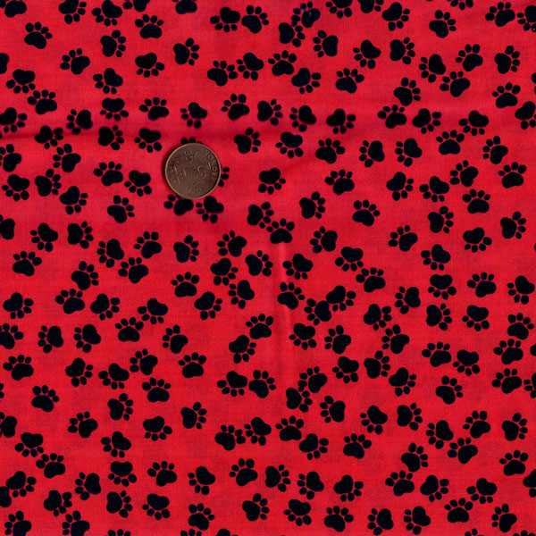 26150 Svarta tassar på röd bas, tygbredd 110 cm.